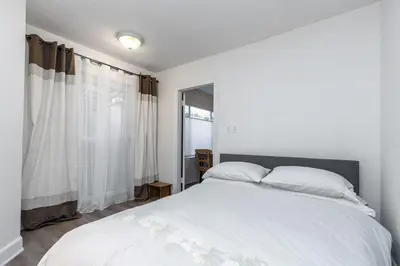 a bedroom with a white bed and a window at Walk to Melrose Ave - World Famous Shops and Restaurants in Los Angeles