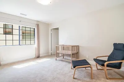 a living room with a chair and a crib at Beautiful 6BR Family 2-Story Villa With Large Backyard and Outdoor Kitchen in Los Angeles