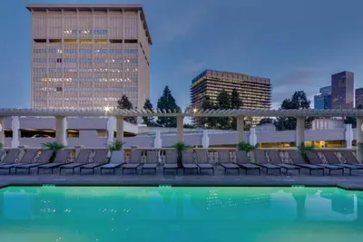 a hotel pool with chairs and buildings in the background at ELEGANT RESORT-SoCal-Lux on 3rd in Los Angeles