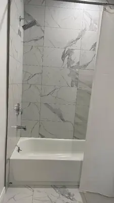 a bathroom with a white tub and marble walls at Luxury mini house in Hughes-Canoga Park Heliport