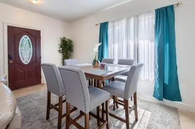 a dining room with a wooden table and chairs at Spacious 2BR Apartment with Full Kitchen & Dining In Beverly Hills in Los Angeles