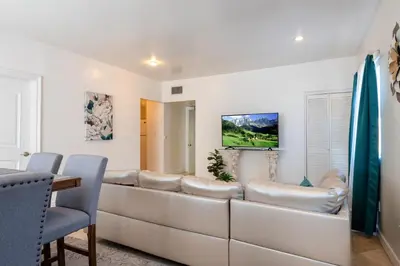 a living room with a large couch and a television at Spacious 2BR Apartment with Full Kitchen & Dining In Beverly Hills in Los Angeles