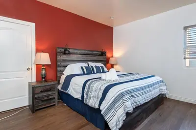 a bedroom with a bed and a red wall at Spacious 2BR Apartment with Full Kitchen & Dining In Beverly Hills in Los Angeles