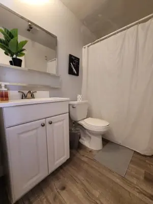 a bathroom with a toilet and a sink and a mirror at Beverly Hills Suite in Los Angeles