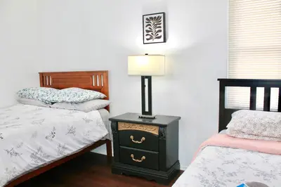 a bedroom with two beds and a lamp on a night stand at Los Angeles Red Rose in Monterey Park
