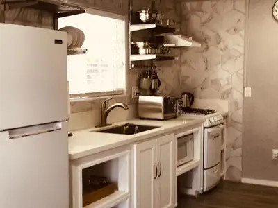 a white kitchen with a sink and a refrigerator at Noah Unit - B in Hawthorne