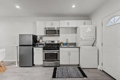 a kitchen with white cabinets and stainless steel appliances at Charming Valley Village Studio Retreat in Los Angeles
