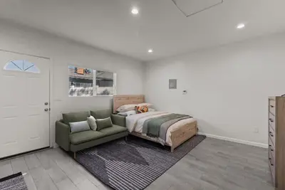 a bedroom with a bed and a green chair at Charming Valley Village Studio Retreat in Los Angeles