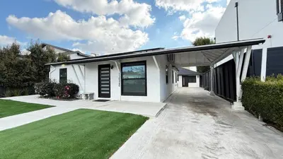 a white house with a porch and a green lawn at Modern Studio Stylish &Cozy Right Unit in Los Angeles