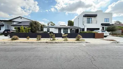 a white house with a fence and a parking lot at Modern Studio Stylish &Cozy Right Unit in Los Angeles