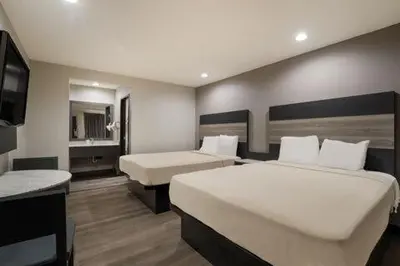 a hotel room with two beds and a television at Rodeway Inn San Bernardino and Redlands in San Bernardino