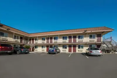 a large building with cars parked in a parking lot at Rodeway Inn San Bernardino and Redlands in San Bernardino