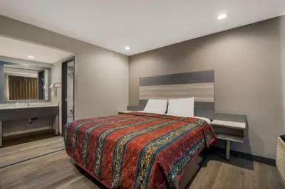 a hotel room with a bed and a sink at Rodeway Inn San Bernardino and Redlands in San Bernardino