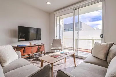 a living room with two couches and a tv at Modern 2BD - 5 min to Santa Monica Pier! in Los Angeles