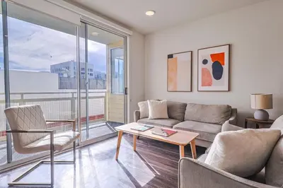 a living room with a couch and a table at Modern 2BD - 5 min to Santa Monica Pier! in Los Angeles