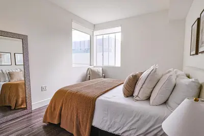 a bedroom with a bed with pillows and a mirror at Modern 2BD - 5 min to Santa Monica Pier! in Los Angeles