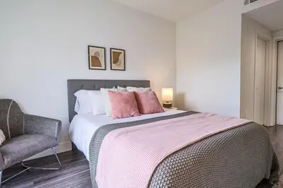 a bedroom with a bed with pink pillows and a chair at Modern 2BD - 5 min to Santa Monica Pier! in Los Angeles