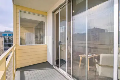 a balcony with sliding glass doors and a couch at Modern 2BD - 5 min to Santa Monica Pier! in Los Angeles
