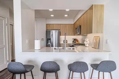 a kitchen with four chairs and a counter with a sink at Modern 2BD - 5 min to Santa Monica Pier! in Los Angeles