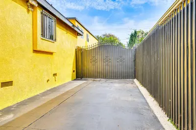 a gate to a building with a fence at 8 Mi to Dtwn LA Apt with Shared Patio! in Los Angeles