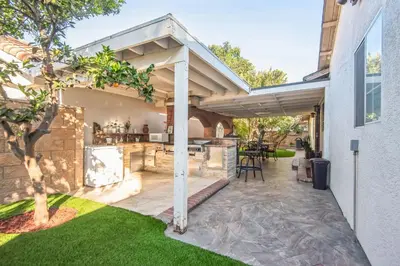 an outdoor kitchen under a pergola on a house at Peaceful Oasis in Anaheim