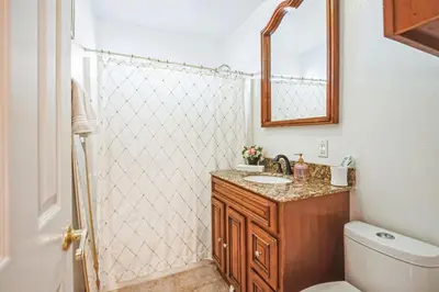 a bathroom with a toilet and a sink and a mirror at Peaceful Oasis in Anaheim