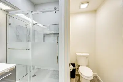 a bathroom with a toilet and a glass shower at 10 Mi to Mojave Narrows Victorville Studio in Victorville