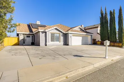 a house with a parking meter in front of a driveway at 10 Mi to Mojave Narrows Victorville Studio in Victorville