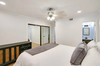 a white bedroom with a bed and a ceiling fan at 10 Mi to Redondo Beach Carson Home with Pool Table! in Carson