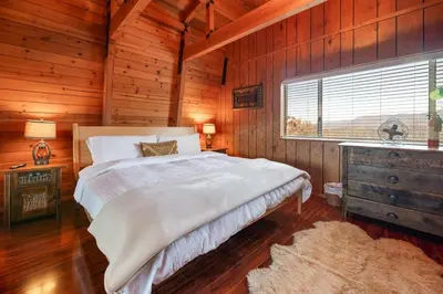 a bedroom with a large bed and a window at The Cedar Bear Lodge, Jacuzzi with an Outdoor Patio & BBQ in Big Bear City Airport