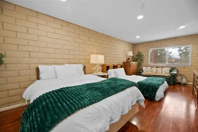 a bedroom with two large beds with green blankets at The Cedar Bear Lodge, Jacuzzi with an Outdoor Patio & BBQ in Big Bear City Airport