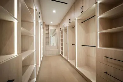 a walk in closet with wooden cabinets and shelves at Woodhill Canyon in Los Angeles