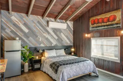 a bedroom with a bed and a wooden wall at Private Deck and Views Frazier Mountain Cabin in Frazier Park