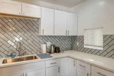 a kitchen with white cabinets and a sink at Private Deck and Views Frazier Mountain Cabin in Frazier Park