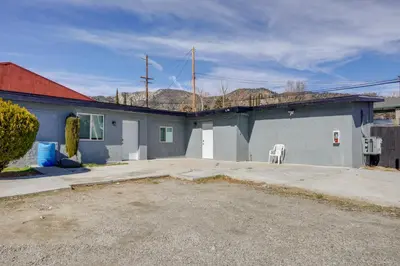a gray building with a white chair in a driveway at Mountain Views Minimalist California Studio in Frazier Park