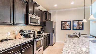 a kitchen with black cabinets and stainless steel appliances at ROM2112 in Los Angeles