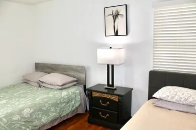 a bedroom with a bed and a lamp on a night stand at Los Angeles Blue Nest in Monterey Park