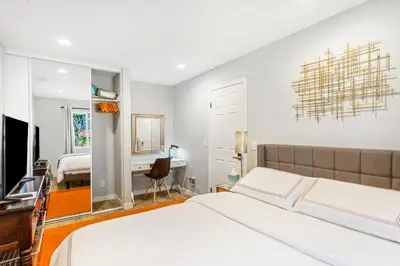 a bedroom with two beds and a desk and a mirror at Remodeled House Near Disneyland in Fullerton