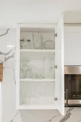 a white cabinet filled with glasses and dishes at Remodeled House Near Disneyland in Fullerton