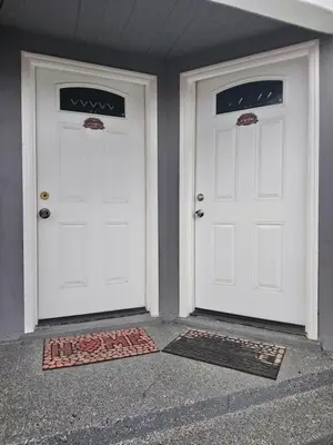 two white doors on a house with mats in front at Vacation Unit is Available for Business and Family Trip in Long Beach