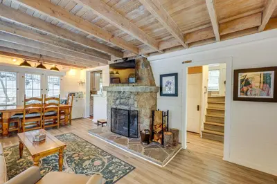 a living room with a fireplace and a dining room at Walkable Green Gables Cottage in Lake Arrowhead in Lake Arrowhead