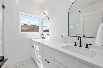 a white bathroom with a large sink and a mirror at Coastal Modern 3 Bed 2 Bath, Pet Friendly in Hawthorne
