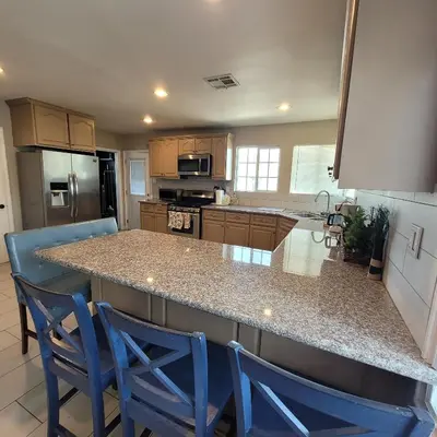 a kitchen with two blue chairs at a counter at 3 bedroom 2 bath home with Jacuzzi near Beverly Hills, wi-fi, Jacuzzi, Roku, BBQ, giant games family fun in Los Angeles