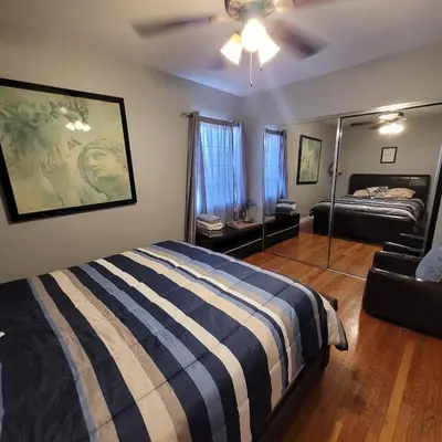 a bedroom with a striped bed and a mirror at 3 bedroom 2 bath home with Jacuzzi near Beverly Hills, wi-fi, Jacuzzi, Roku, BBQ, giant games family fun in Los Angeles