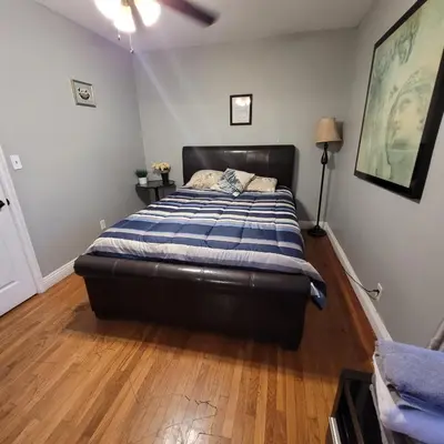 a bedroom with a bed with a blue and white blanket at 3 bedroom 2 bath home with Jacuzzi near Beverly Hills, wi-fi, Jacuzzi, Roku, BBQ, giant games family fun in Los Angeles