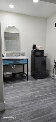 a room with a counter and a sink and a mirror at Hotel Avenida - Victorville, Hesperia, Apple Valley, I-15 in Victorville