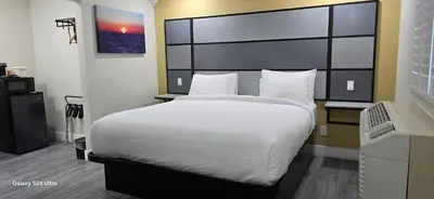 a bedroom with a large bed with white sheets and pillows at Hotel Avenida - Victorville, Hesperia, Apple Valley, I-15 in Victorville