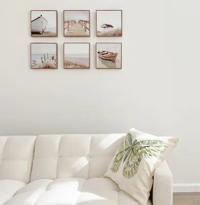 a white couch with four pictures on a wall at Seaside Escape Steps from Santa Monica Beach in Los Angeles