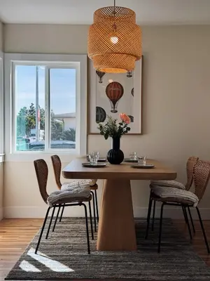 a dining room table with chairs and a vase with flowers at Cozy Private Room A in S Central LA in Los Angeles