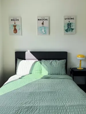 a bedroom with a bed and two posters on the wall at Cozy Private Room C in S Central LA in Los Angeles